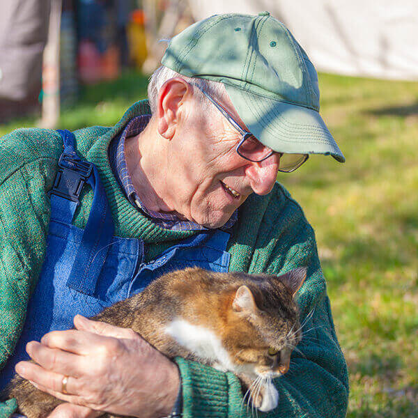 How Pets Benefit Disabled - Elderly man with his pet cat smiling