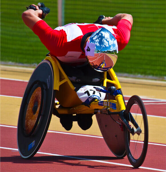 Wheelchair Athelete Running - Wheelchair Racing on Paralympic Track in Aerodynamic Position