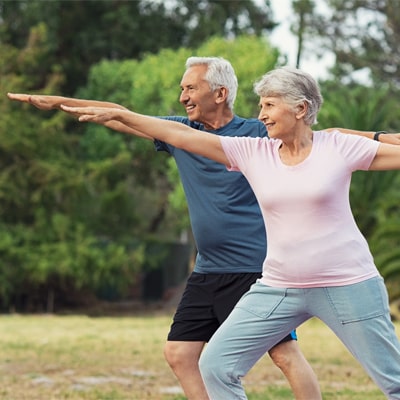 Activities for People with Arthritis - Old couple doing yoga in the sun