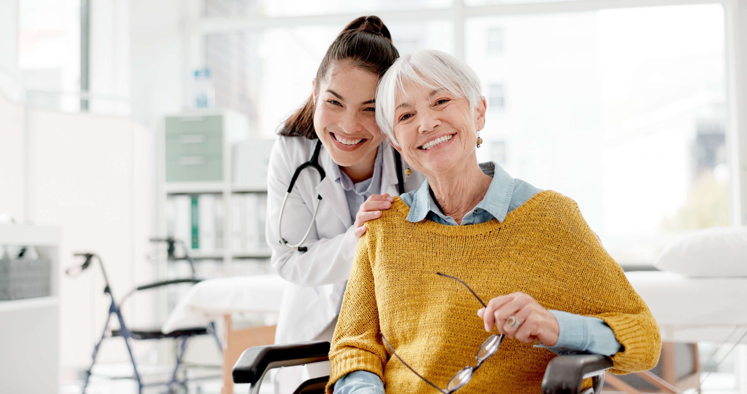 Older-Lady-and-Doctor-Smiling-with-Mobility-Stroller-in-Background-1-scaled